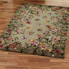 a rug with flowers and butterflies is on the floor in front of a wooden floor