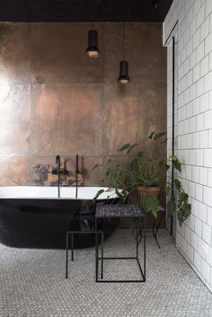 a bath tub sitting next to a plant in a bathroom