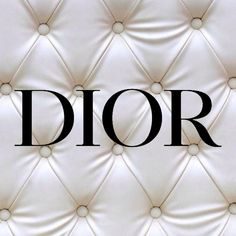 the word dior written on a white leather upholstered wall