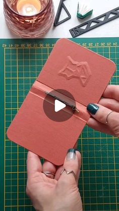 a person is cutting up a piece of red paper with scissors and some other items