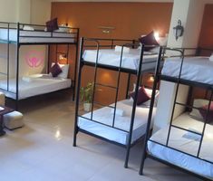 bunk beds are lined up in a room with white tile flooring and brown walls