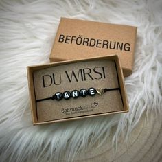 a couple of bracelets sitting on top of a white fur covered floor next to a box