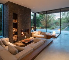 a living room filled with furniture and a fire place in front of a large window