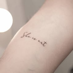 a woman's arm with the word she is not written in cursive writing