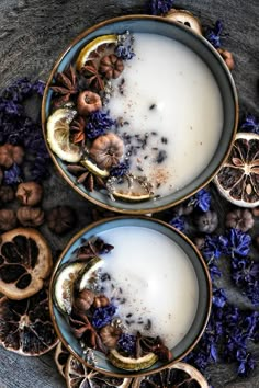 two cups filled with milk surrounded by dried fruit