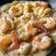 pasta with shrimp and cream sauce in a black bowl