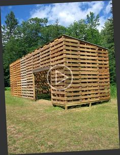 a large wooden structure sitting in the middle of a field