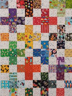 a quilt made with many different colors and designs on the front, side, and back