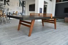 a ping pong table sitting in the middle of a room with chairs around it