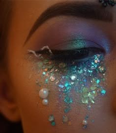 a woman's face with glitter on her eyes