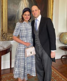 a man and woman standing next to each other in front of a painting