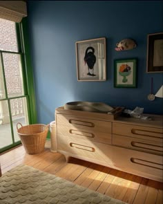 a baby crib in front of a window with green shutters and pictures on the wall