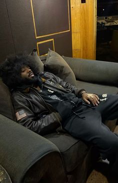 a man laying on top of a couch in a living room next to a wall