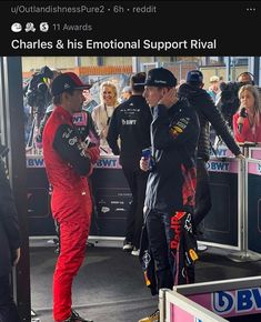 two men in red racing suits talking to each other