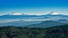 the mountains are covered with snow in the distance, as seen from an overlook point