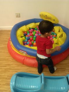 a young boy playing in an inflatable ball pit