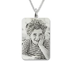 a necklace with a drawing of a young boy on it's front and back sides