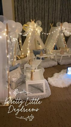 a room filled with lots of white balloons and lights on top of the floor next to a laptop computer