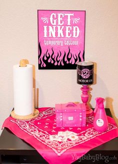 a table topped with pink items next to a sign