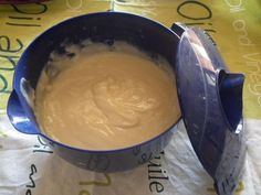 a blue bowl filled with batter sitting on top of a white cloth covered tablecloth