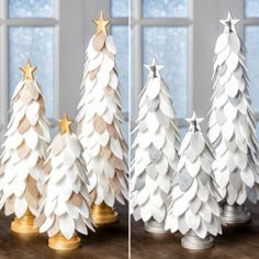 three white paper christmas trees with gold stars on them and one is made out of cardboard