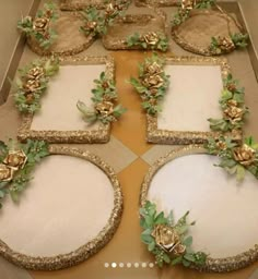 there are many decorated plates on the table with gold trimmings and green leaves