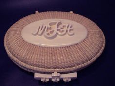 a white wicker basket with the word ms & t on it sitting on a blue surface