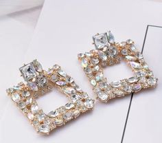 This is a beautiful and elegant pair of Rhinestone earrings with push-back closure. It is super lightweight as well. Perfect for gifting! JEWELRY SIZE - Length : 1.81 inches - Width : 1.38 inches MATERIAL : - High quality and durability - Crafted in quality base JEWELRY CARE - Remove jewelry before shower, swimming and strenuous activities. - Clean your jewelry regularly. - Store your jewelry in a clean, dry place Please treat your jewelry with care. Keep them away from moisture. SHIPPING - DOME Party Earrings In Diamond White With Diamond Accents, Diamond White Earrings With Diamond Accents For Party, Glamorous Bling Diamond White Earrings, Glamorous Diamond White Earrings With Bling, Party Earrings With Sparkling Stones In Diamond White, White Crystal Earrings With Diamond Accents For Party, Party White Crystal Earrings With Diamond Accents, Diamond White Earrings With Sparkling Stones For Party, Rhinestone Statement Earrings