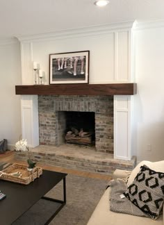 a living room with a fire place and couches in front of the fireplace,