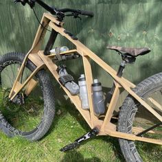 a wooden bicycle parked next to a green wall