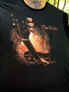 a black shirt with the words the reals on it