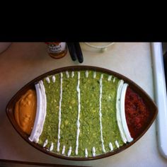 a platter filled with guacamole and sauces on top of a table