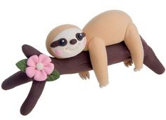 a toy slotty is sleeping on a tree branch with a flower in its mouth