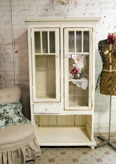 a white cabinet sitting next to a chair in a room