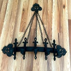 an ornate iron chandelier hangs on a wood floor