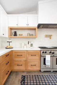 a kitchen with wooden cabinets and an oven in the center, along with a rug on the floor