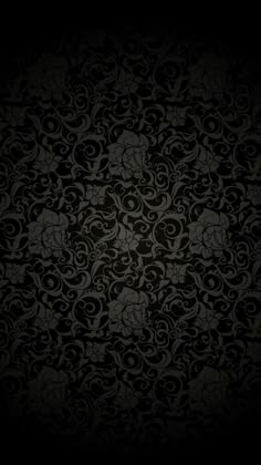 an ornate black wallpaper with swirls and scrolls on it's sides, in the dark