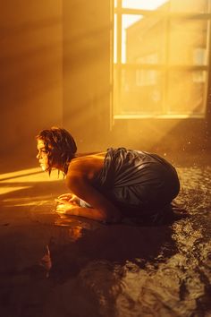 a woman kneeling on the ground in front of a window