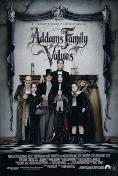 a group of people standing in front of a sign that says adams's family values