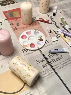 the table is covered with candles and other crafting supplies