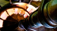 a close up view of the top of an old fashioned metal pipe and some chairs in the background