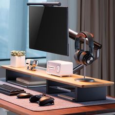 a computer desk with headphones on it and a monitor sitting on top of it