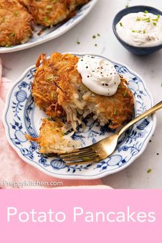 potato pancakes with sour cream and chives on a blue and white plate next to a pink napkin