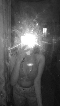 a woman taking a selfie in front of a mirror with the light shining on her face