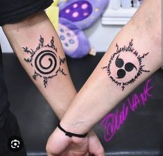 two people holding hands with tattoos on their arms and one has a spiral design on the wrist