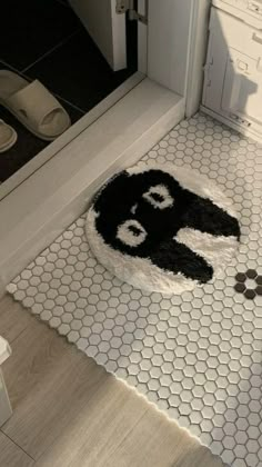 a black and white rug sitting on top of a bathroom floor