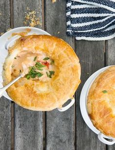 two pies sitting on top of white plates and one has a spoon in it