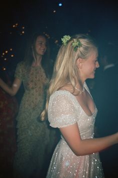 a woman in a white dress standing next to another woman