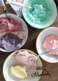 three bowls filled with different types of cake frosting on top of a wooden table