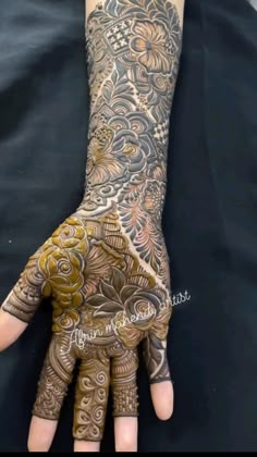 a person's hand covered in hennap with flowers and swirls on it